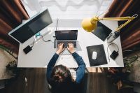 Foto: Frau sitzt im Homeoffice beim Schreibtisch und arbeitet am Laptop