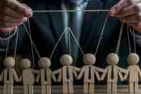 Puppenspieler im Anzug mit Holzpuppen